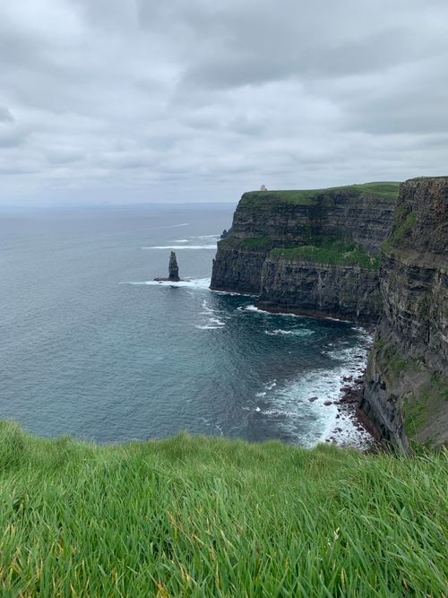 Free Majestic Cliffs of Moher, Ireland, with lush grass and dramatic ocean views. Stock Photo