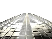 低角度镜头拍摄一座具有玻璃立面和钢结构的现代摩天大楼