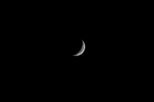 Free A striking crescent moon set against a deep dark night sky. Stock Photo