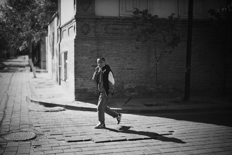 A Boy Walking On The Street 