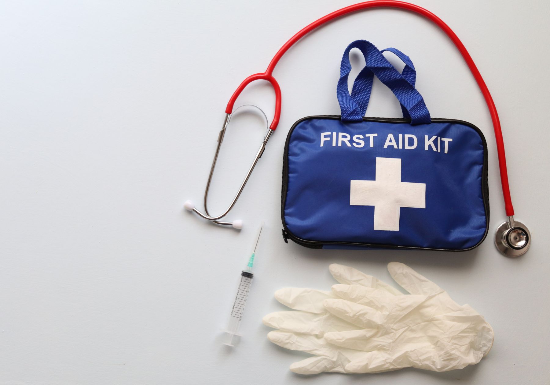 First-aid kit with practical care supplies arranged neatly on a clean white surface