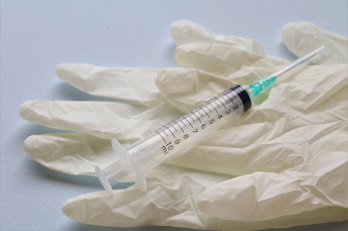 Syringe on Latex Gloves