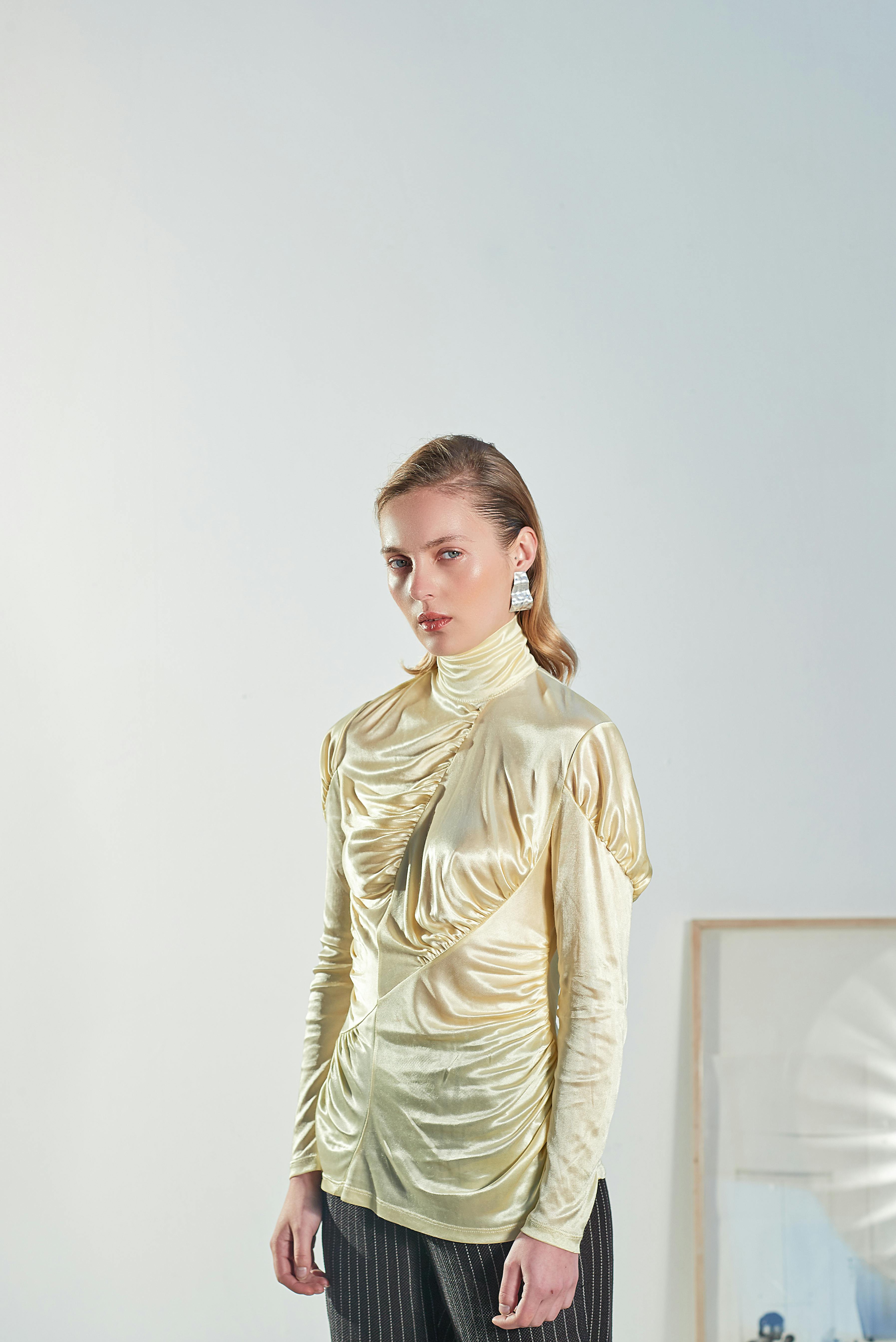 a woman wearing gold long sleeves