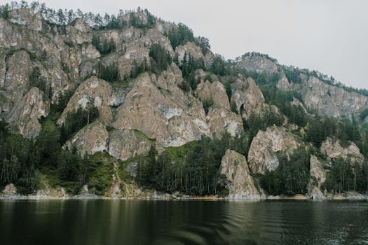 Beautiful rocky cliff formations surrounded by lush greenery and a calm river.
