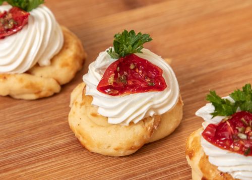 Free From above of catering appetizer with delicious chou buns with cream and sun dried tomatoes on board Stock Photo