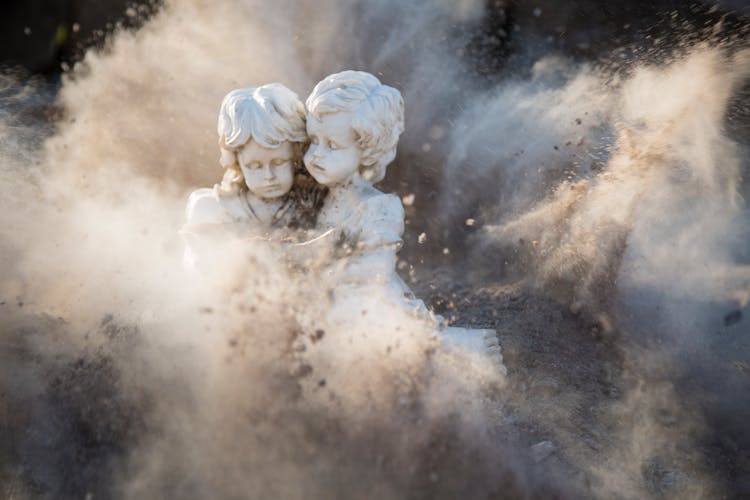 Two White Concrete Statues Covered By Dust