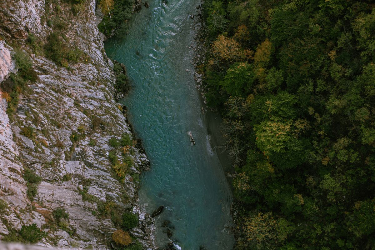 Fotografie din dronă cu un râu lângă o faleză