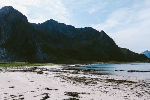 Free Landscape of wide sandy coast washed by sea water located among steep rocky mountains Stock Photo