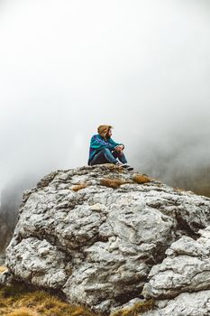 一个年轻人在雾霭笼罩的岩石山上沉思，捕捉到了孤独与自然的本质