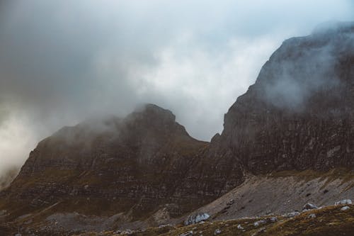 Brown Rocky Mountain surrounded with Fog 