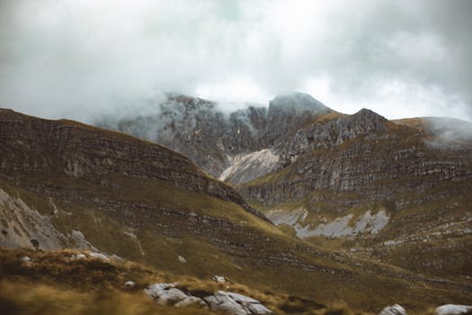 Dramatic mist covered rocky mountain landscape with a hazy atmosphere.