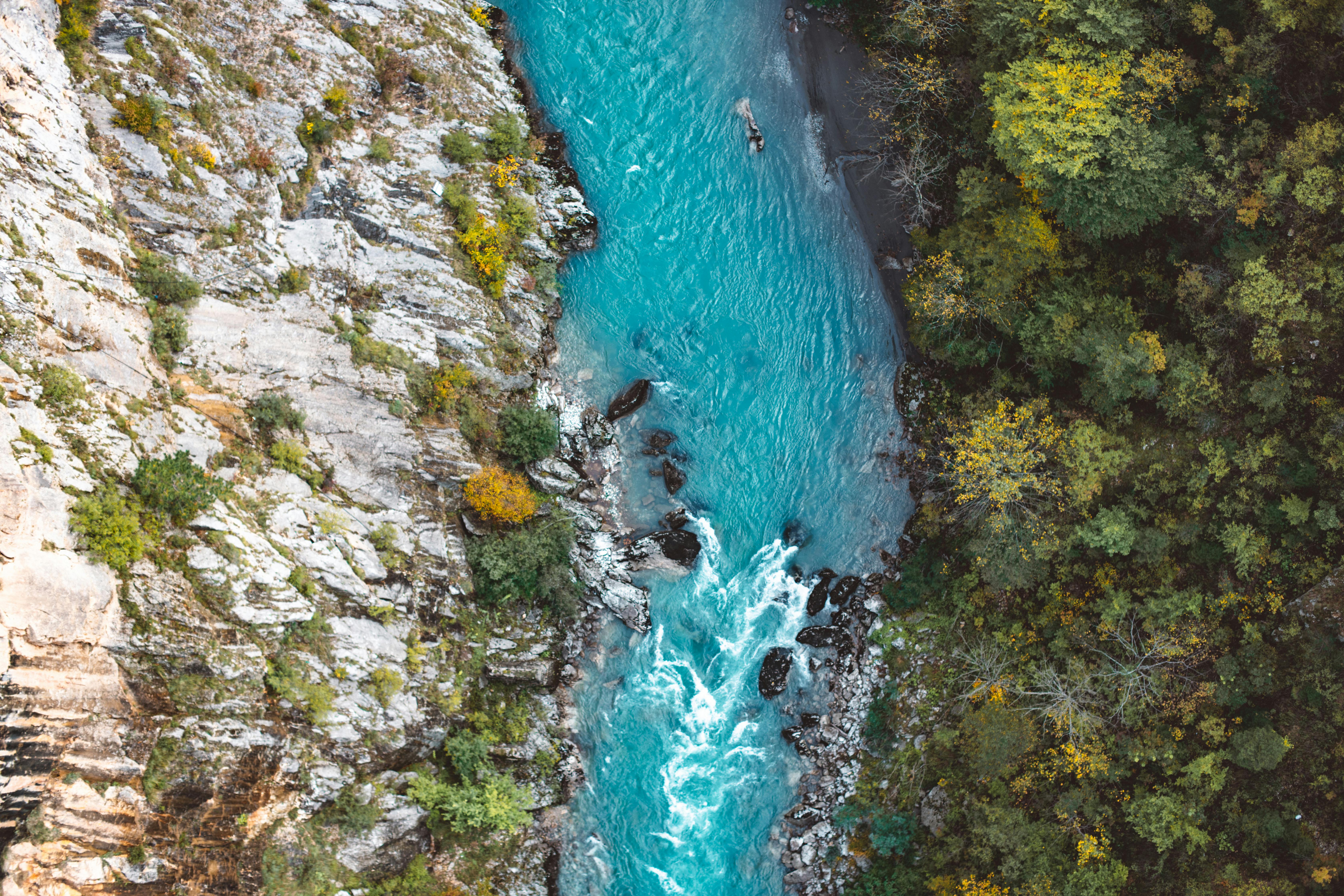 drone photography of river beside cliff