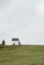 White Wooden House on Green Grass Field Under White Sky