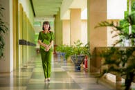 A Woman in Green Military Uniform Standing on Hallway