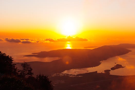 A breathtaking sunrise over a coastal landscape with vibrant orange and yellow hues.