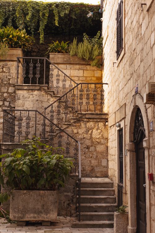 Free Rustic staircase amidst stone walls and greenery, ideal for architectural themes. Stock Photo
