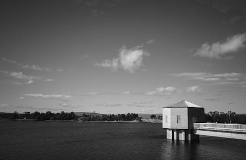 Grayscale Photo of House Near Body of Water