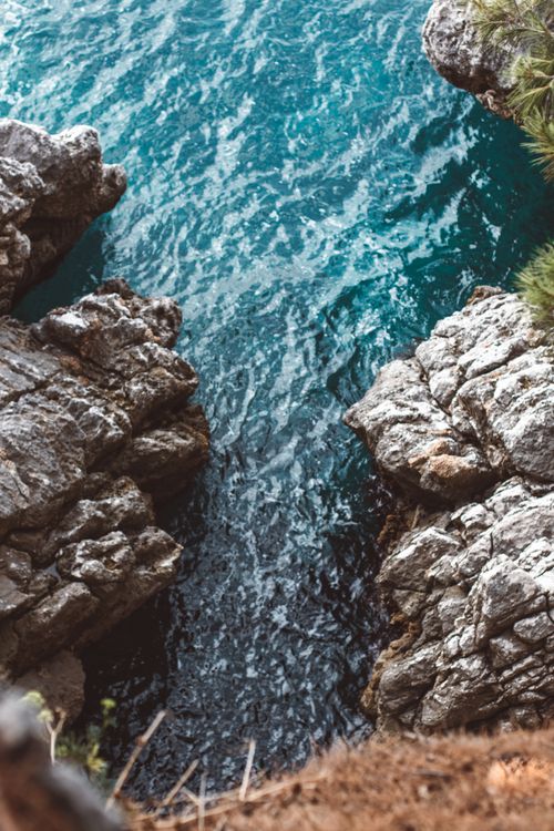 Free A tranquil view of turquoise waters flowing through rocky cliffs in a tropical location. Stock Photo