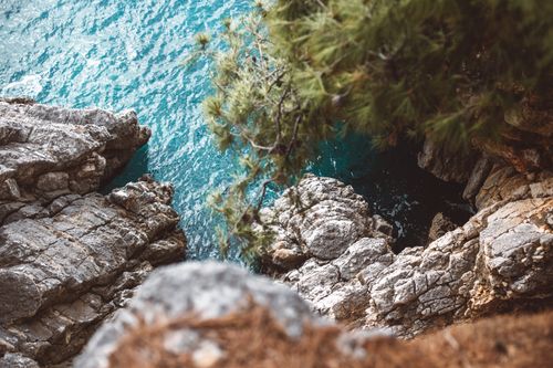Free Capture of rugged cliffs overlooking a vibrant blue ocean with lush greenery. Stock Photo