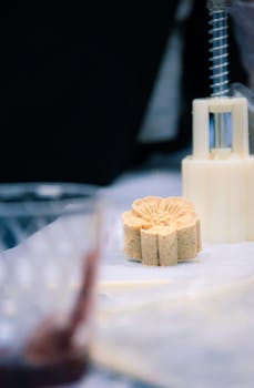 Detailed view of mooncake crafting with a mold, showcasing traditional Chinese culinary art.