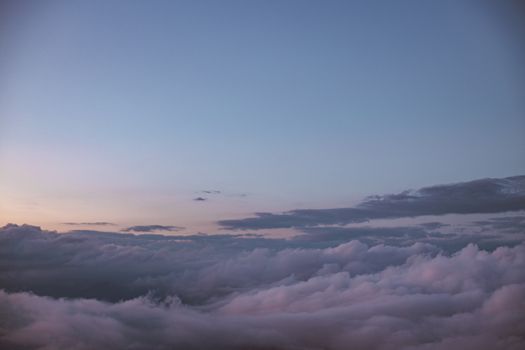 黄昏的天空映衬着柔和的粉红色云彩，景色宁静而美丽，非常适合自然爱好者