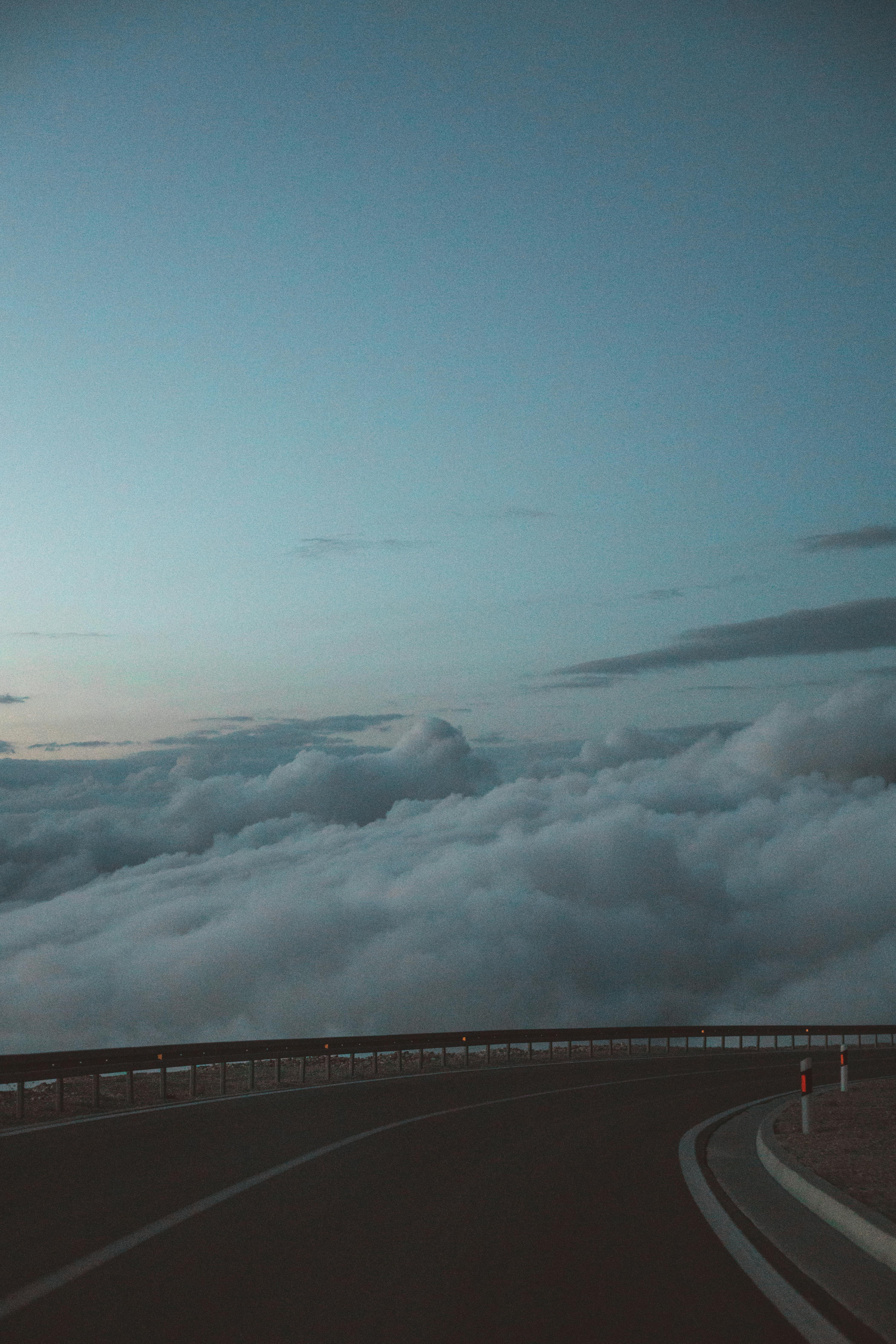 黎明时分，一条宁静的高速公路蜿蜒在云层上，营造出梦幻般的风景