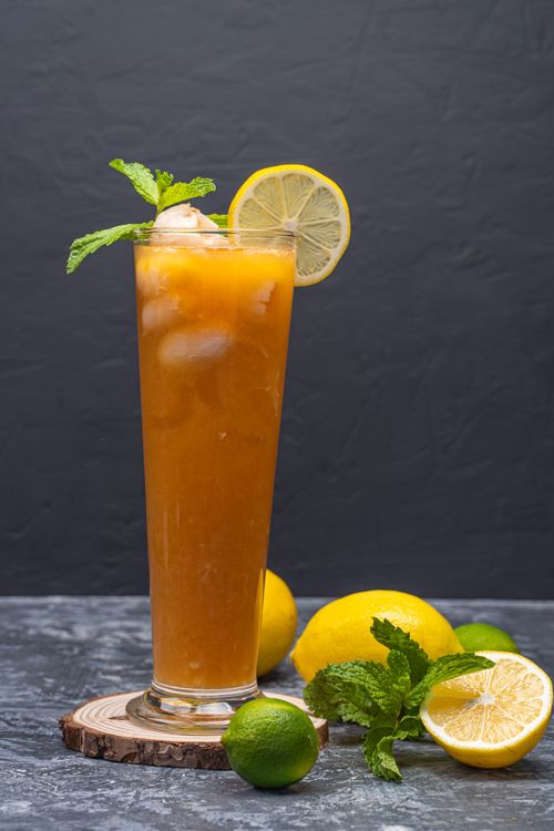 Free Chilled citrus drink with lemon and lime garnishes, ideal for a refreshing summer treat. Stock Photo
