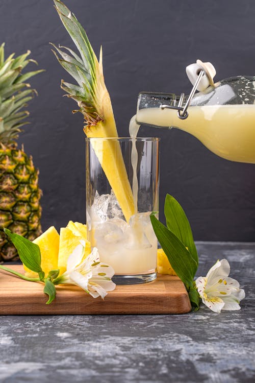 Free Pouring Pineapple Juice in the Glass Stock Photo