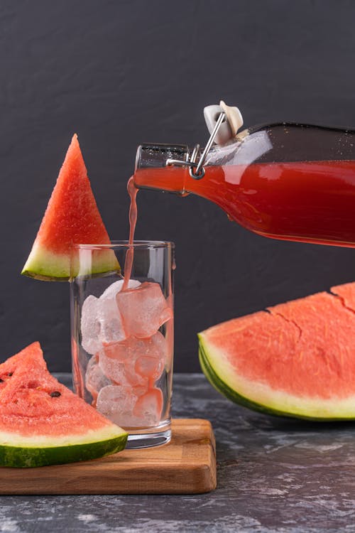 Clear Drinking Glass With Red Liquid and Sliced of Watermelon