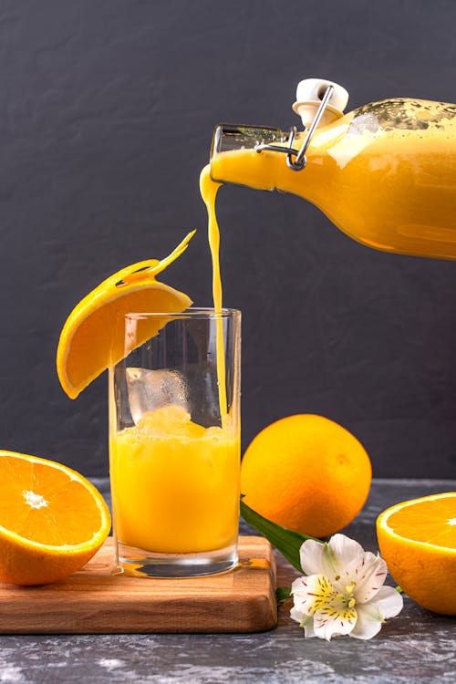 Free A Pouring Fresh Orange Juice in the Glass Stock Photo
