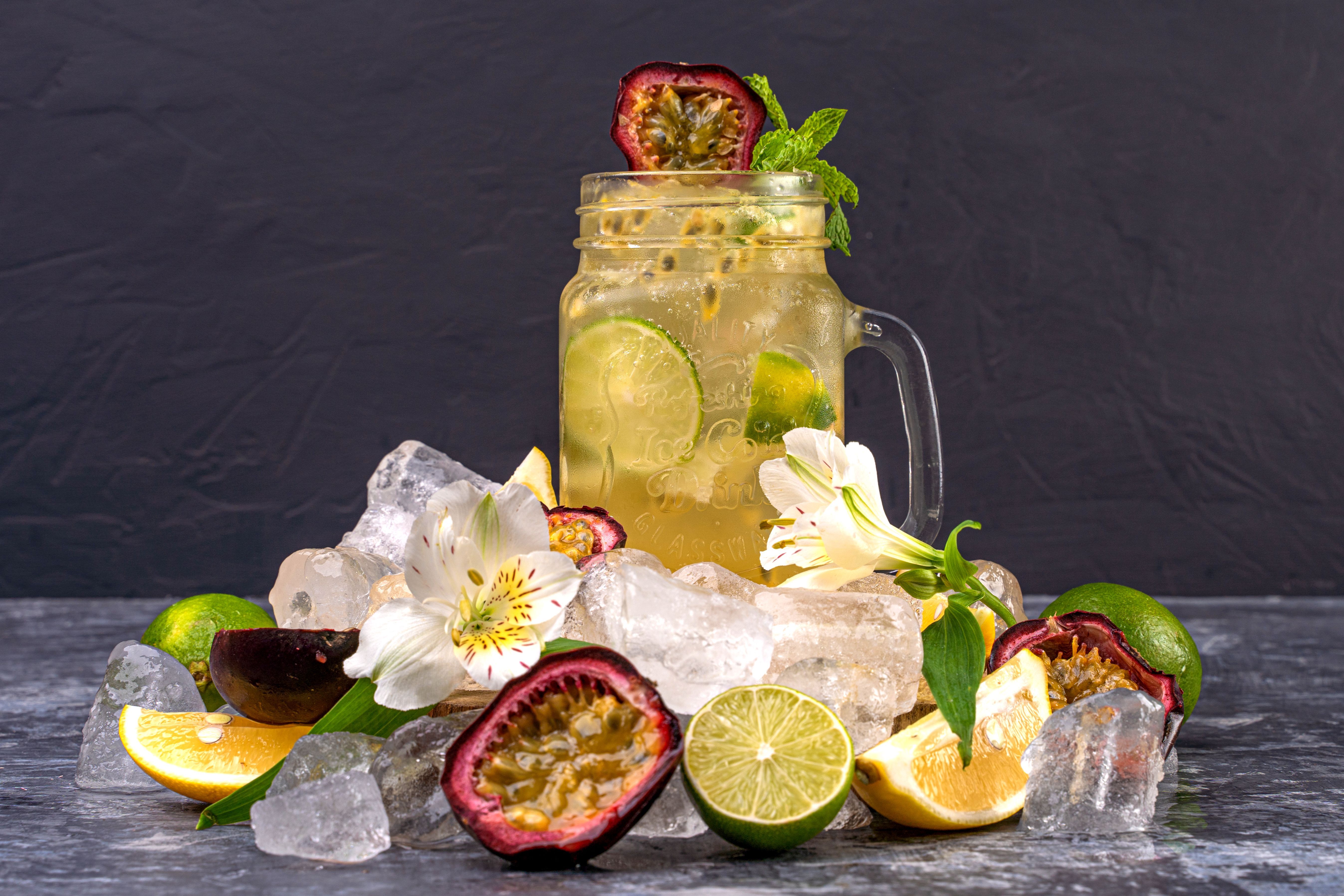 A vibrant citrus and passion fruit drink surrounded by ice, creating a refreshing sensory experience.