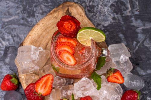 Free Top view of a strawberrry lime drink with ice cubes on rustic wood. Stock Photo