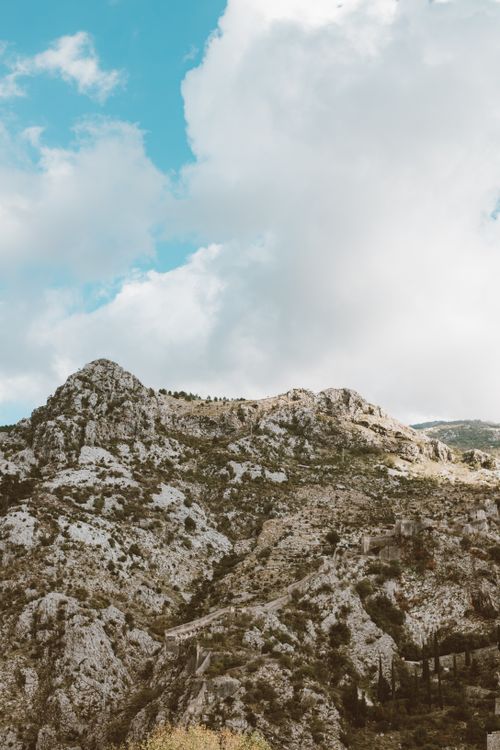 Free Breathtaking view of a rugged mountain range beneath a cloudy sky, showcasing natural rock formations. Stock Photo