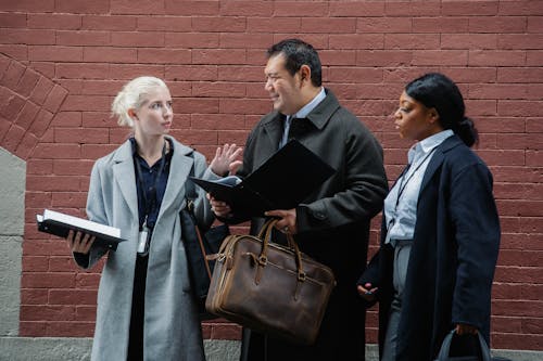 Multiethnic colleagues speaking about business issues on street