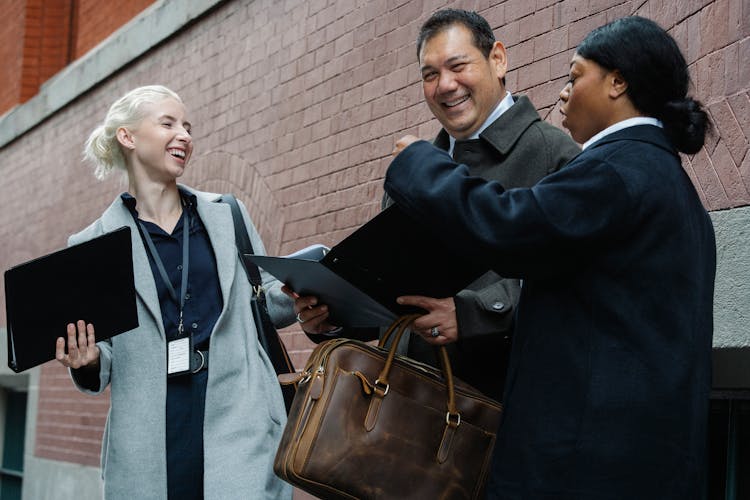 Positive Diverse Coworkers Chatting On Street After Business Meeting