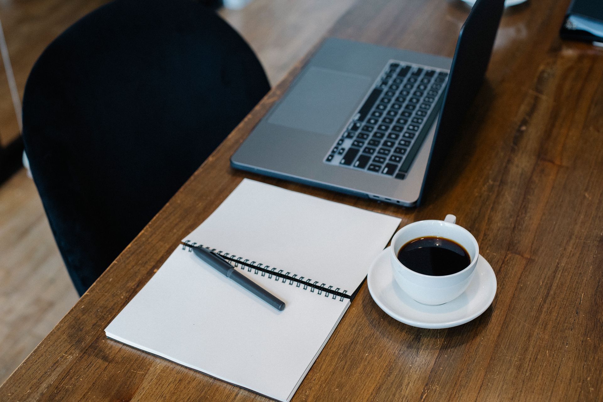 Arbeitsplatz mit Laptop und Notizbuch für die Recherche in der GEMA-Datenbank