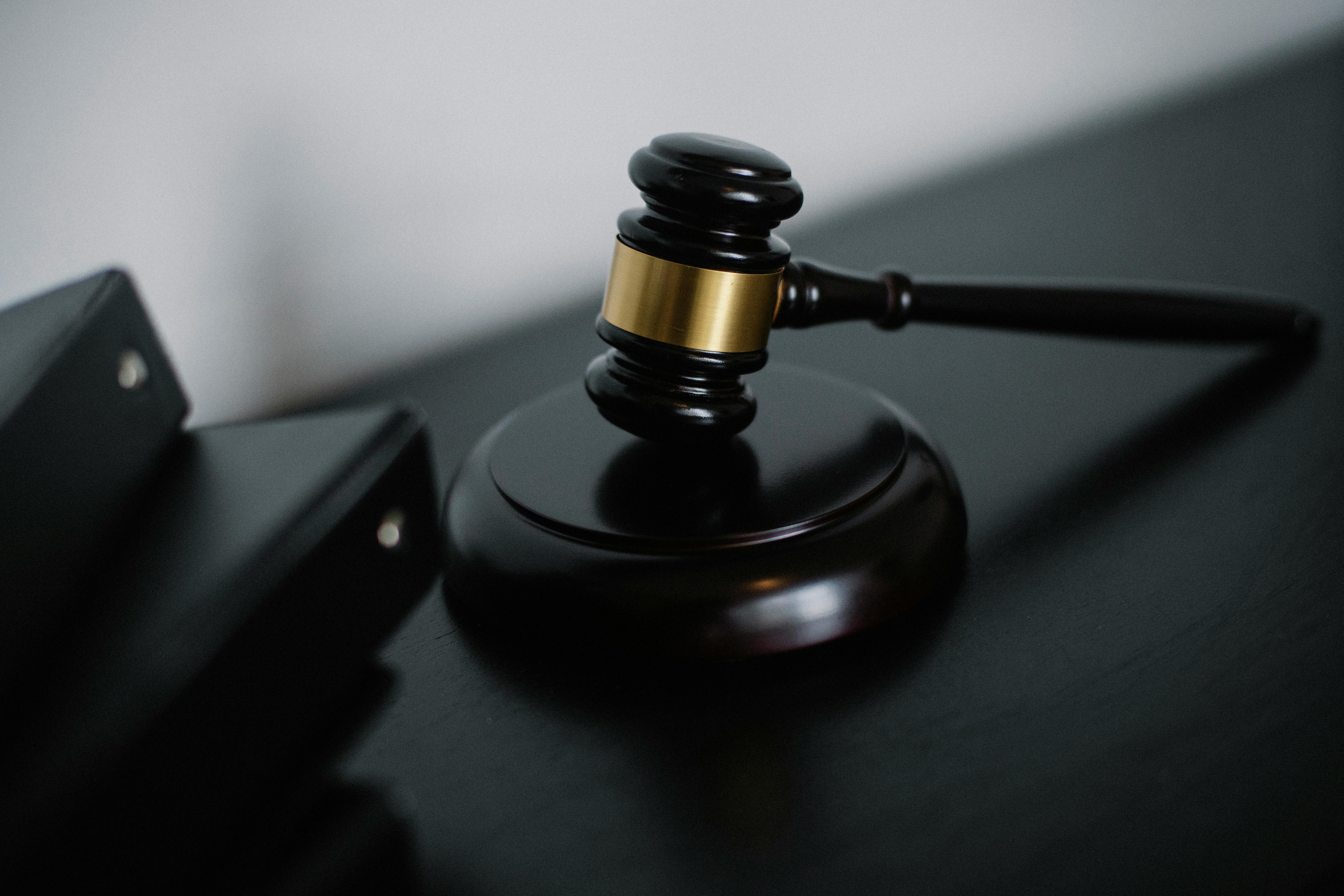 Small judge gavel placed on table near folders. | Photo: Pexels