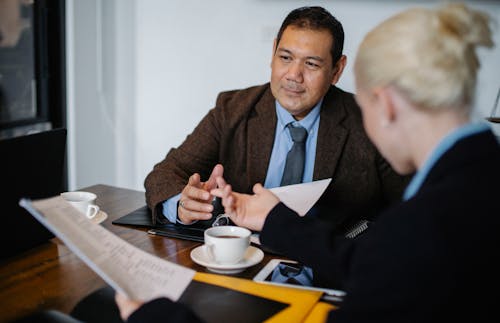 Concentrated multiracial colleagues communicating in office during teamwork with documents