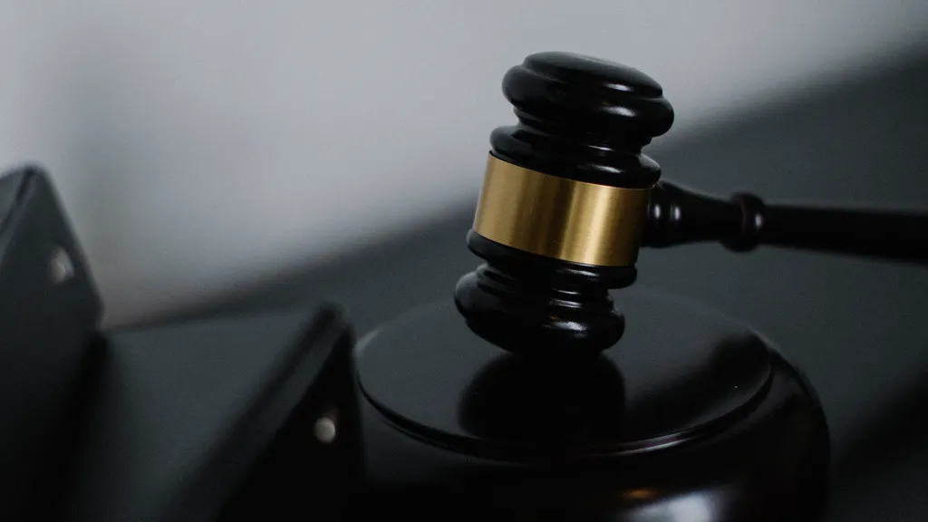 Wooden gavel on a table beside a stack of folders