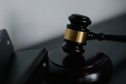Wooden gavel on a table beside a stack of folders