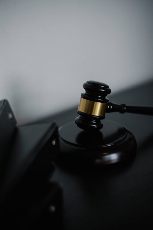 Free Black wooden gavel with golden strip on table near stack of folders in courthouse Stock Photo