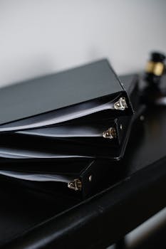 Close-up of neatly stacked black office binders on a desk, symbolizing organization.