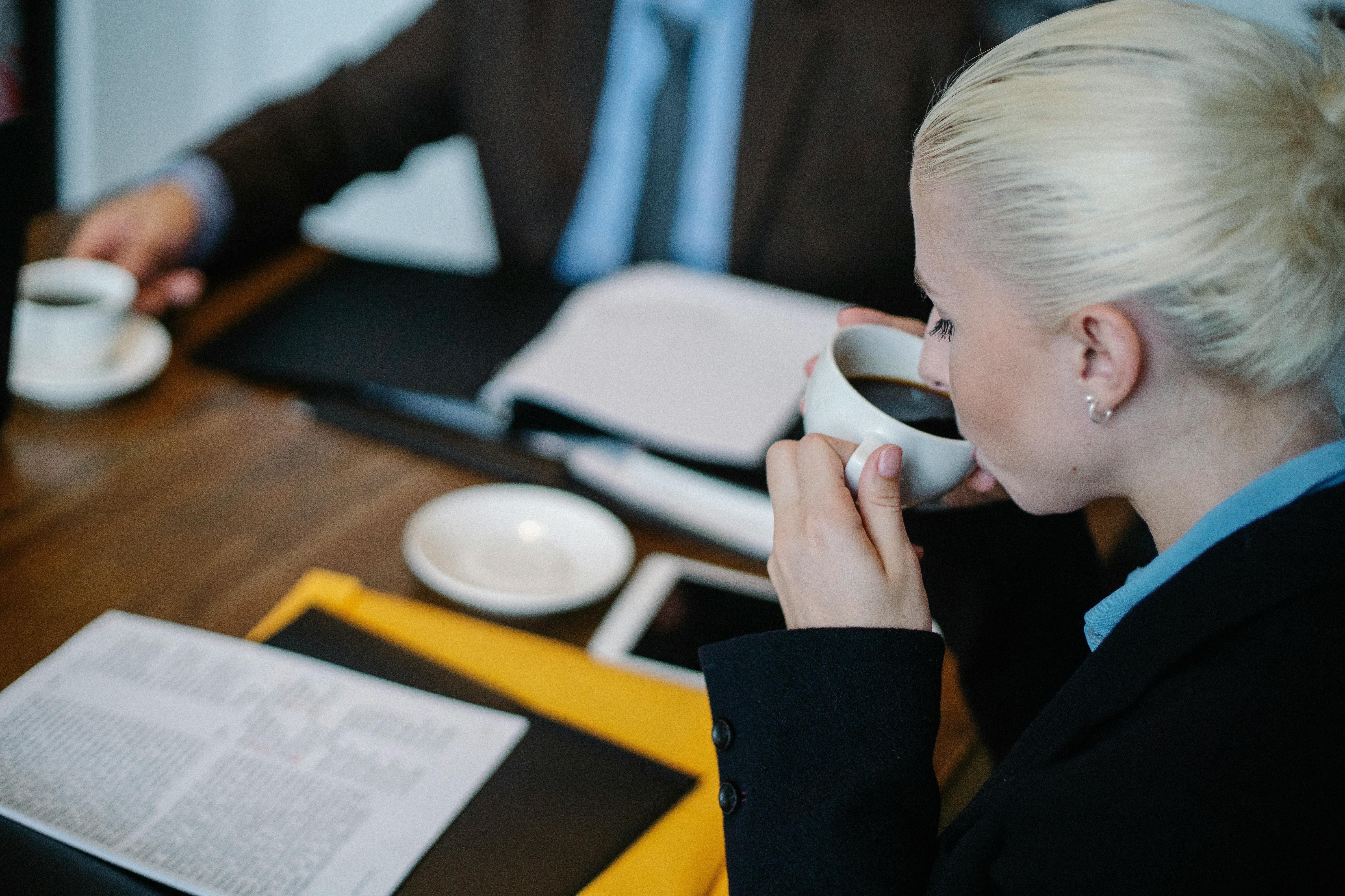 thoughtful woman drinking coffee during brainstorm