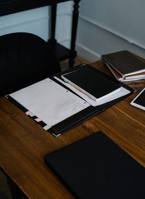 Workspace with notepads and tablet in office