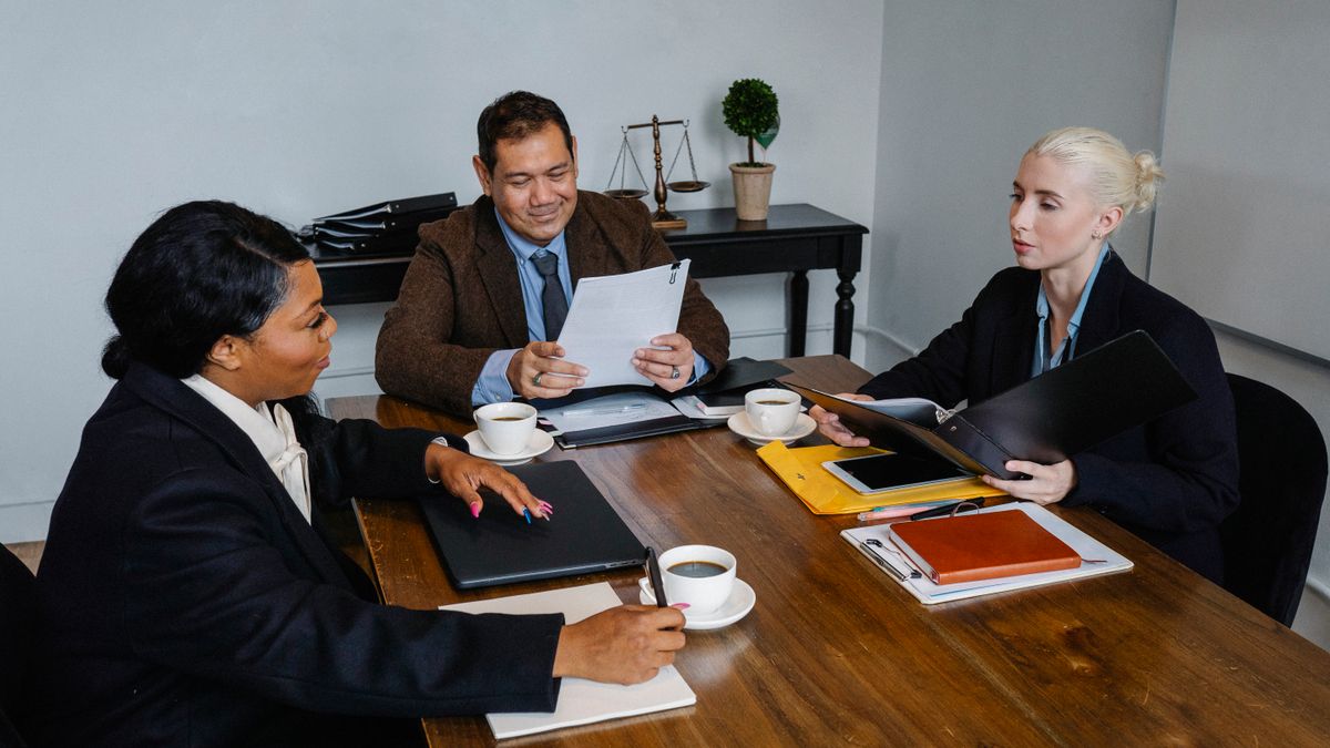Group of diverse coworkers in formal suits discussing business issues during meeting in office