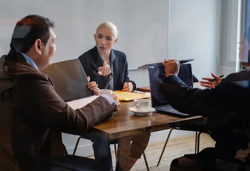 A diverse group of professionals collaborating during a business meeting in an office setting.