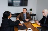 一群同事在办公室成功举行商务会议后，完成交易并握手