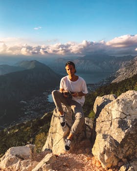 男人穿着休闲装，欣赏壮丽山景，拥抱大自然的美丽