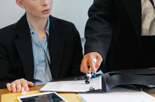 Free Crop colleagues in formal wear checking documents Stock Photo