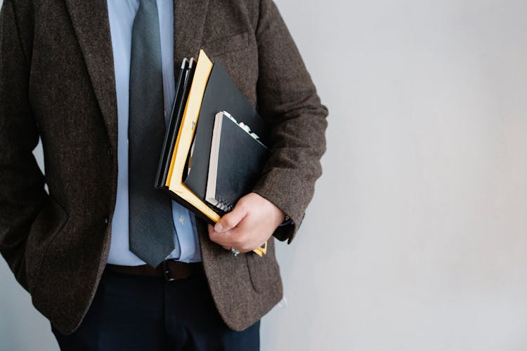 Crop Unrecognizable Office Worker Standing With Papers In Hand